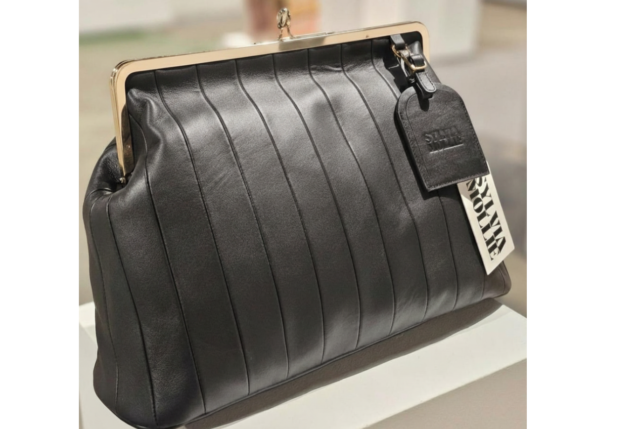 Black leather kiss-lock handbag with a panelled front by Sylvia Mollie
