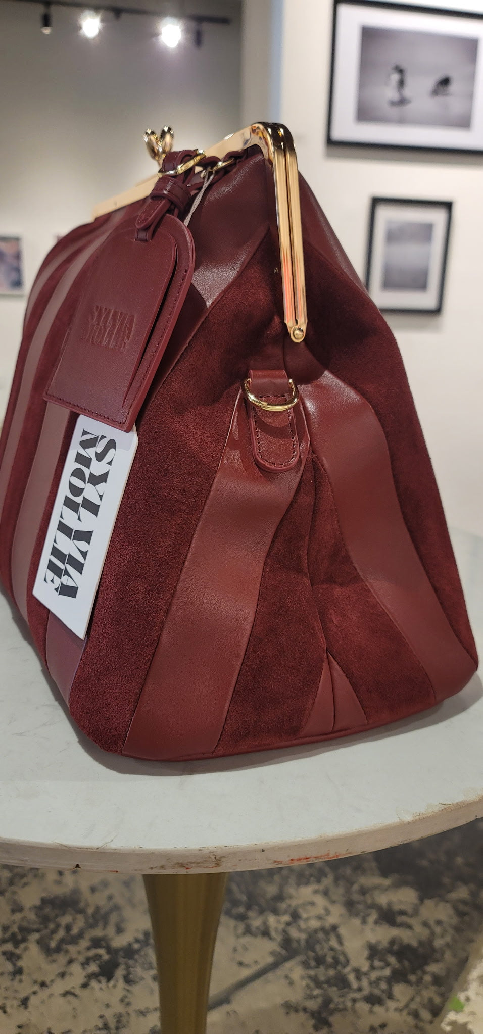 Red handbag with a visible brand label on a white surface.