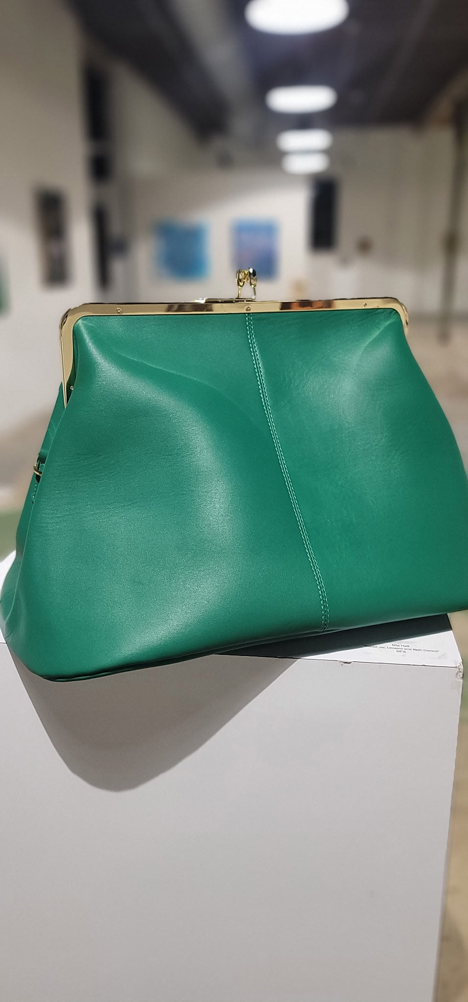The Fannie Bag in green leather showing the kiss-lock frame and hangtag