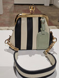 The Lil Fannie mini bag in black and ecru striped leather with a gold kiss-lock frame, sage hangtag and chain strap