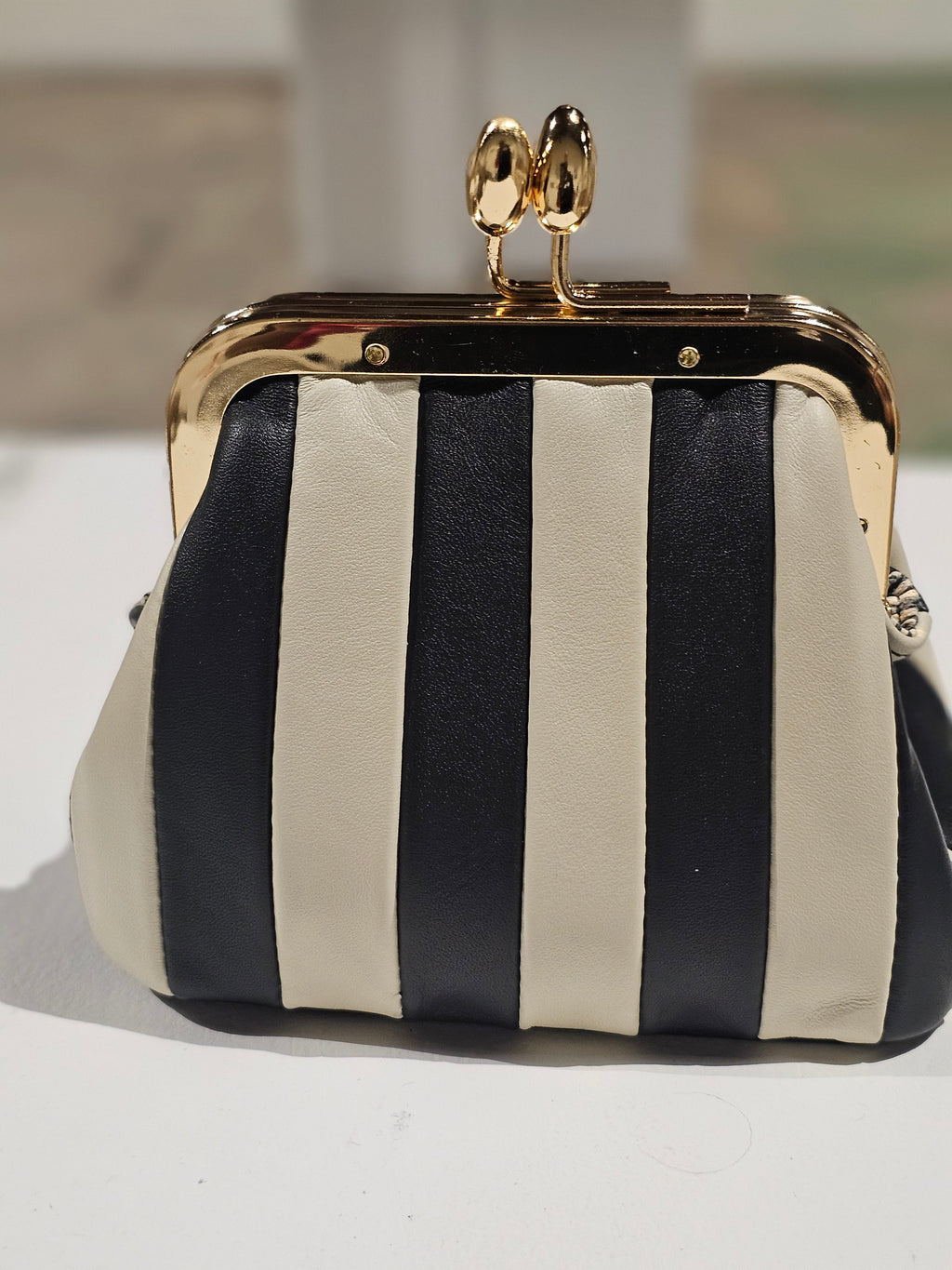 Mini striped leather bag with a sage green leather hangtag