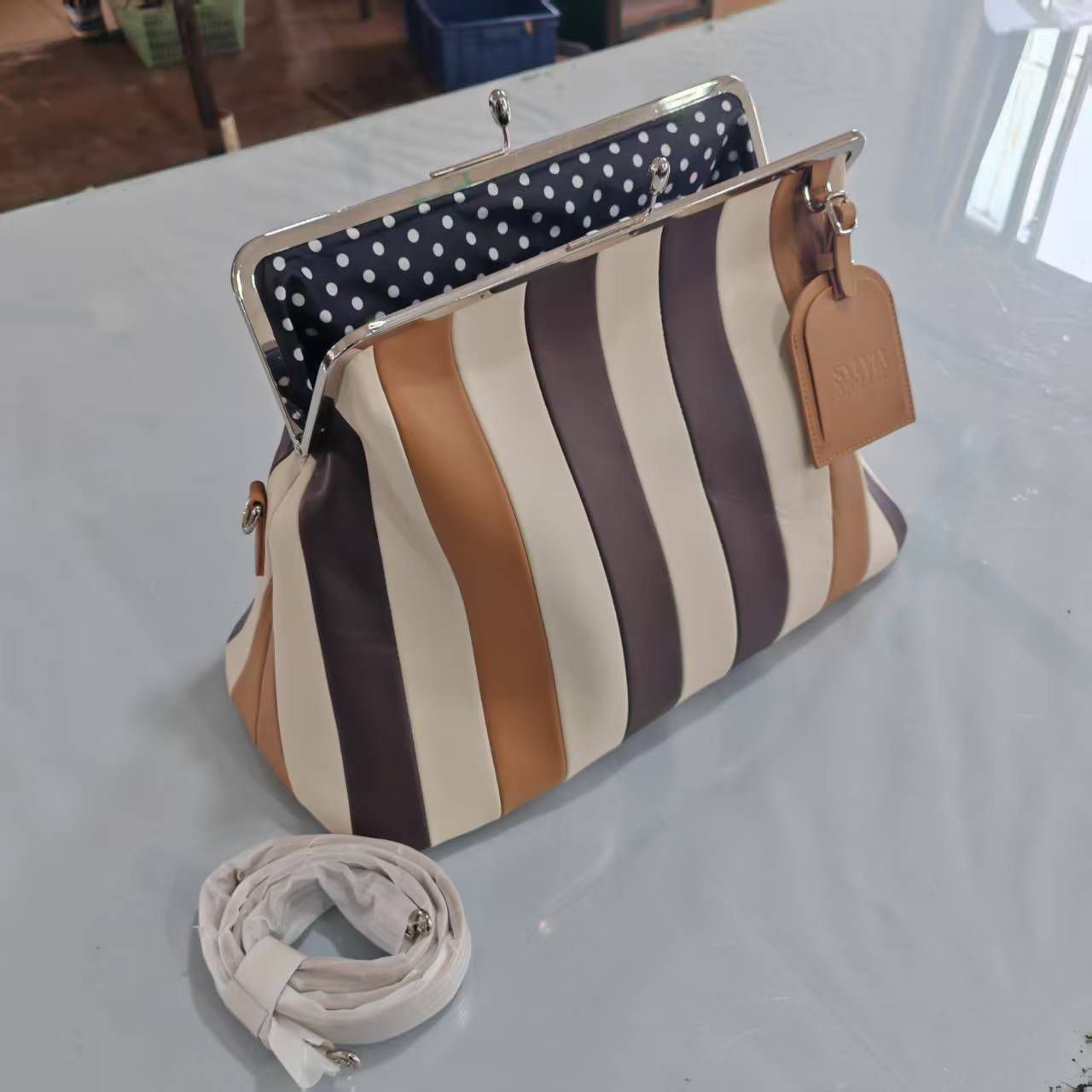 The Fannie Bag in Choco Mix with an embossed leather hangtag