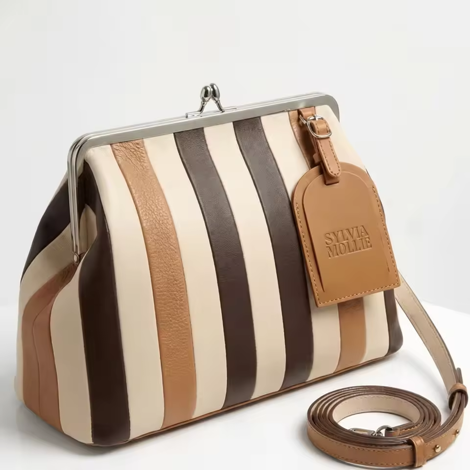 The Fannie Bag in Choco Mix: cream, chocolate and tan striped leather with a silver kiss-lock frame and crossbody strap